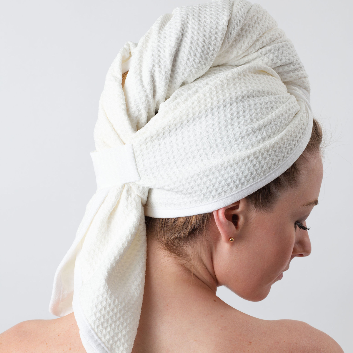 Back view of a woman with her hair wrapped in the GWEN Hair Towel in Ivory.