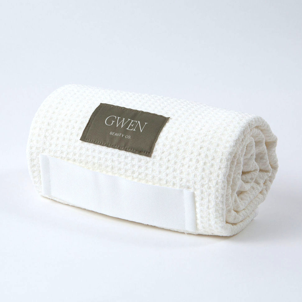 The GWEN Hair Towel in Ivory rolled up, showing the waffle weave microfiber texture.