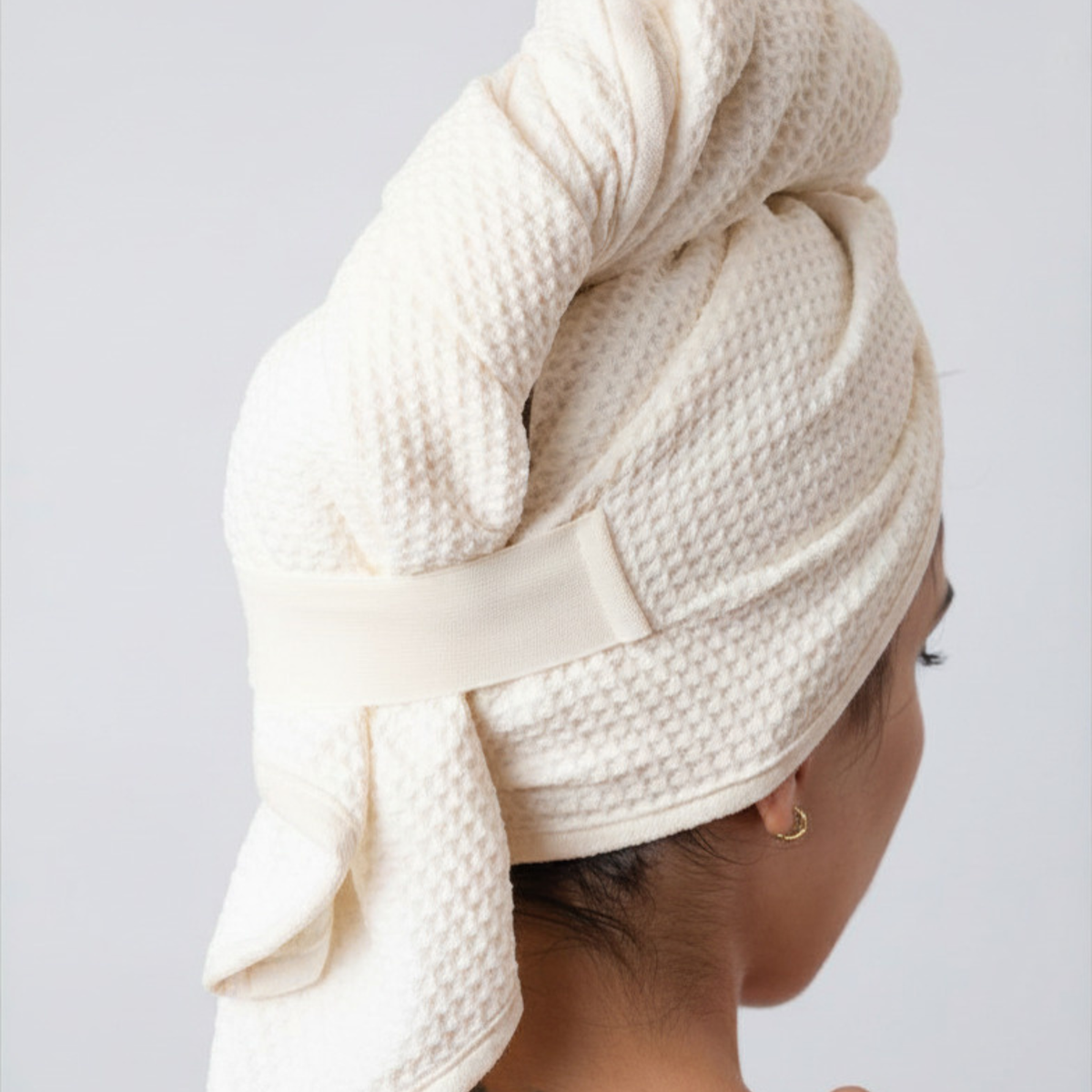 Back view of a woman with her hair wrapped in the GWEN Hair Towel in Linen.
