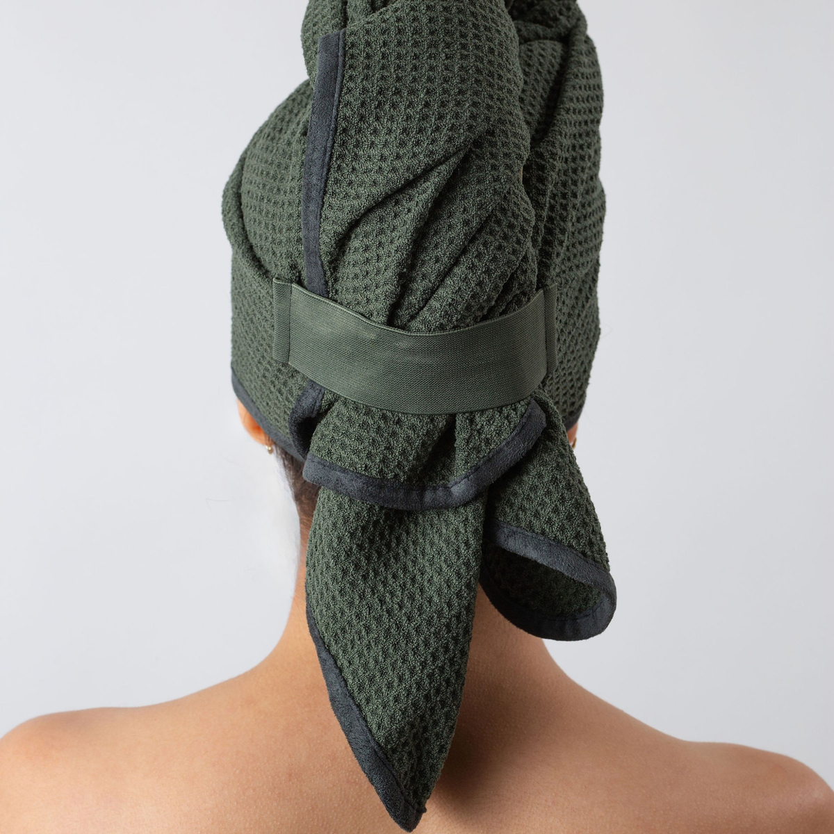 Back view of a woman with her hair wrapped in the GWEN Hair Towel in Moss.