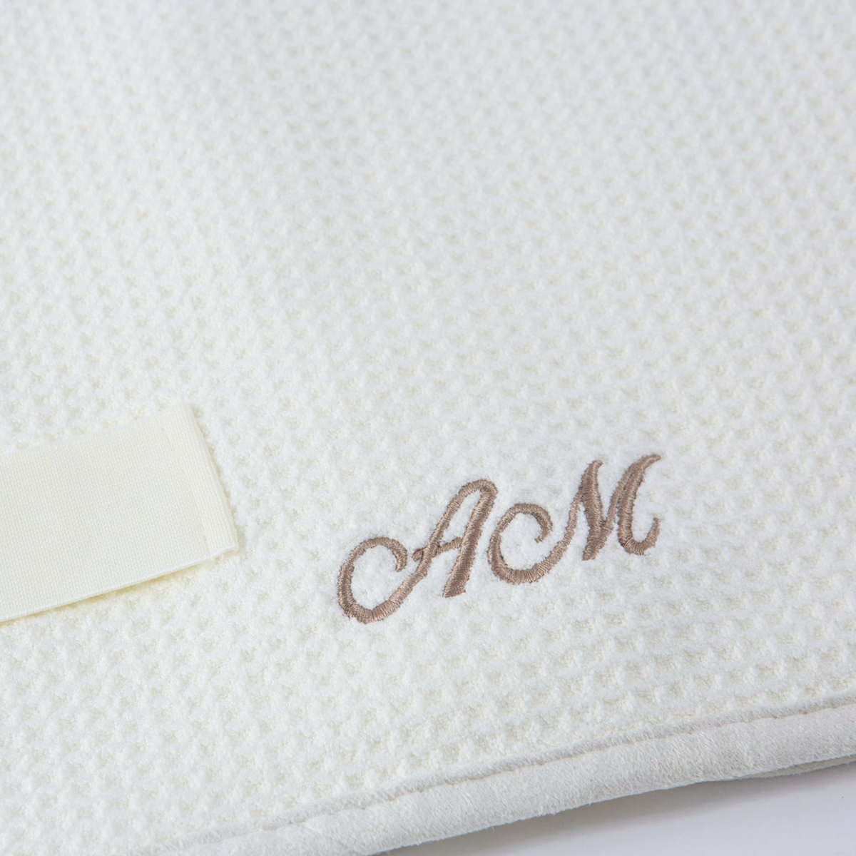 Close-up of the GWEN Hair Towel in Linen with an embroidered monogram, showing the personalization add-on.
