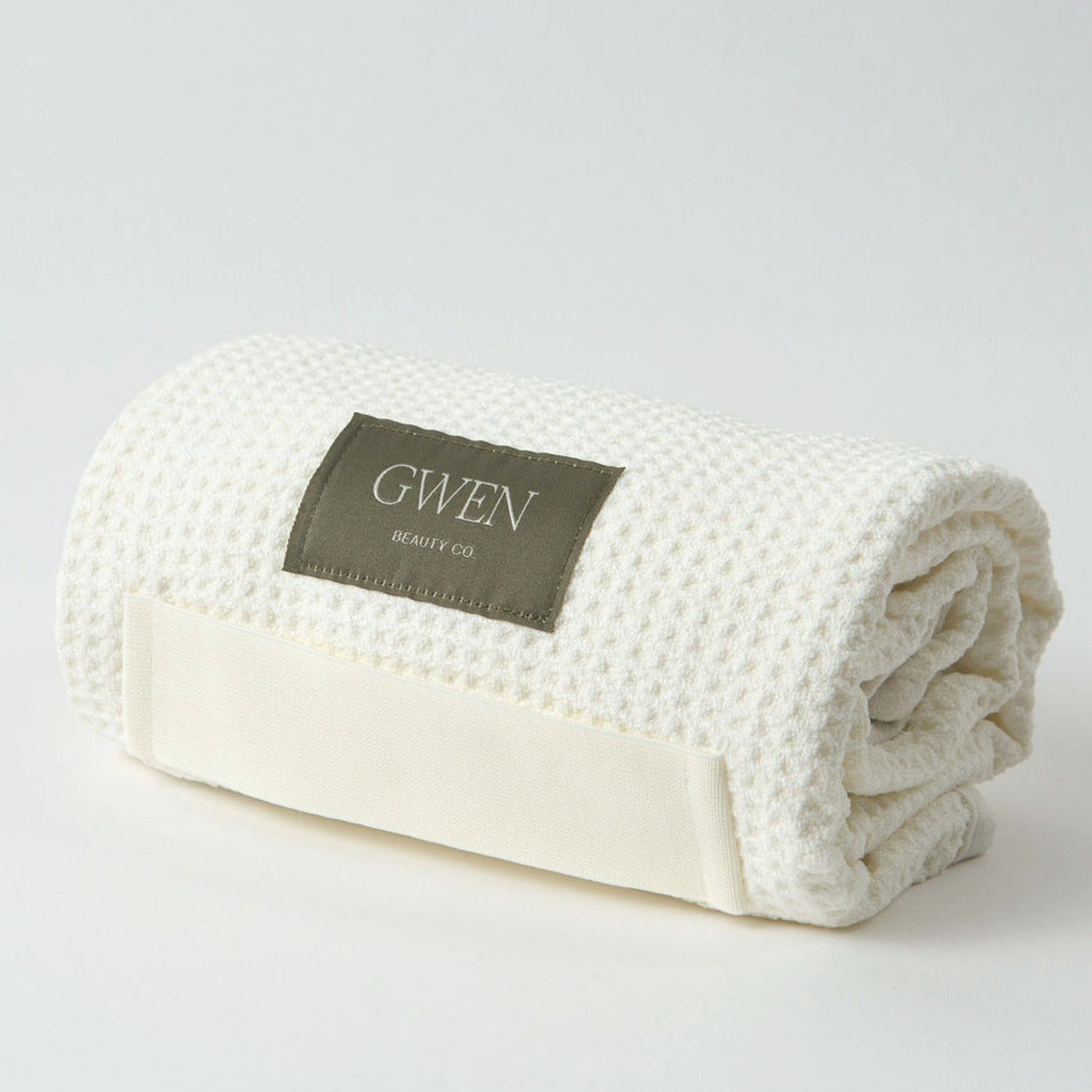 The GWEN Hair Towel in Linen rolled up, showing the waffle weave microfiber texture.