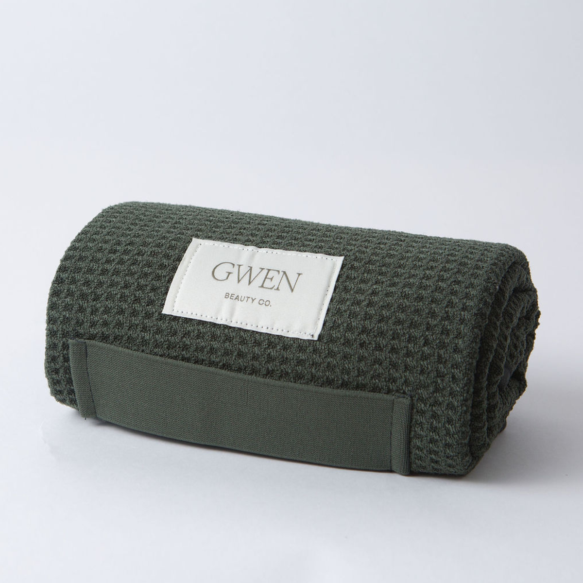 The GWEN Hair Towel in Moss rolled up, showing the waffle weave microfiber texture.