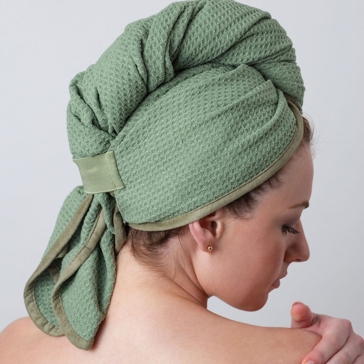 Back view of a woman with her hair wrapped in the GWEN Hair Towel in Sage.